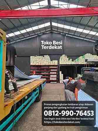 Proses pengangkutan lembaran atap Alderon panjang dari gudang ke truk pengiriman